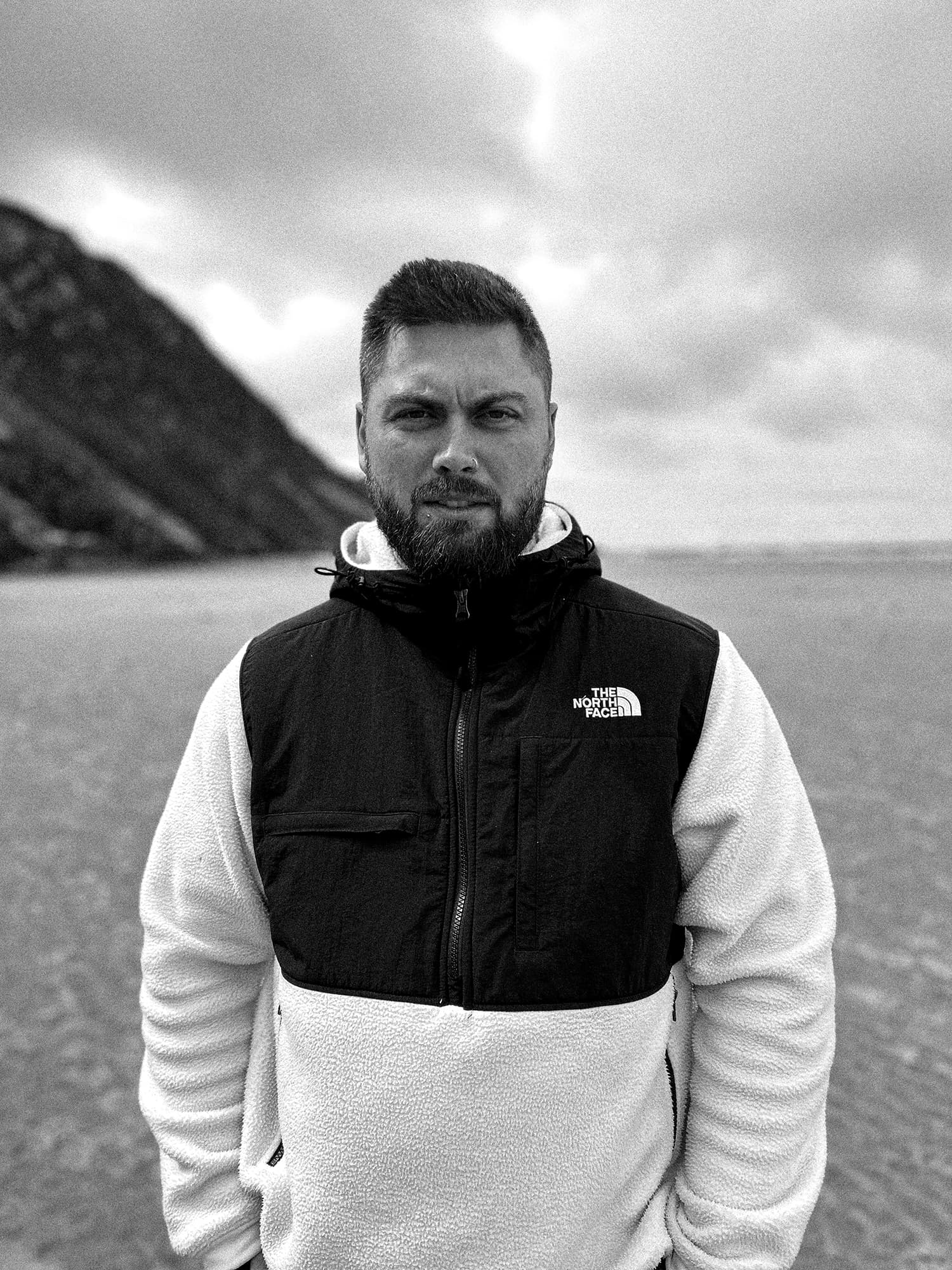 Portrait of Ben on a beach with mountain backdrop