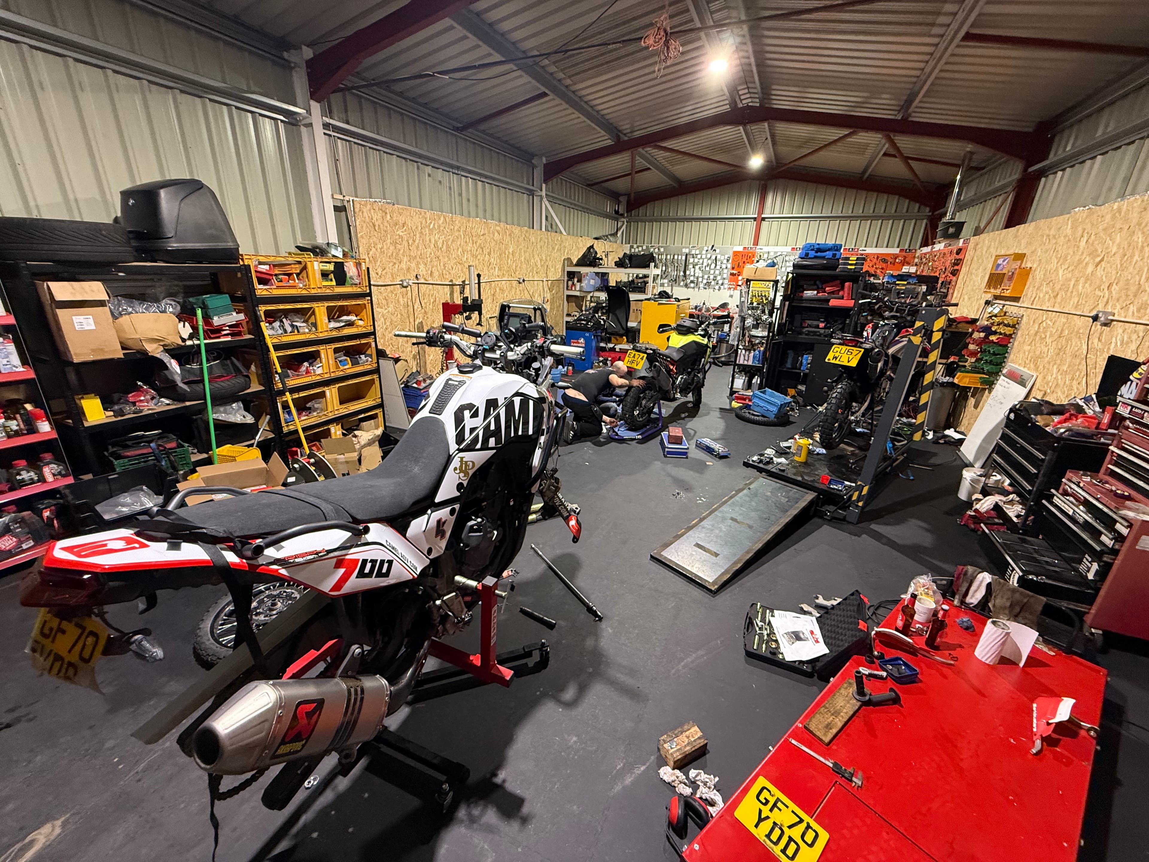 A workshop with a Beta 390 RR on a bike lift, tools and parts around